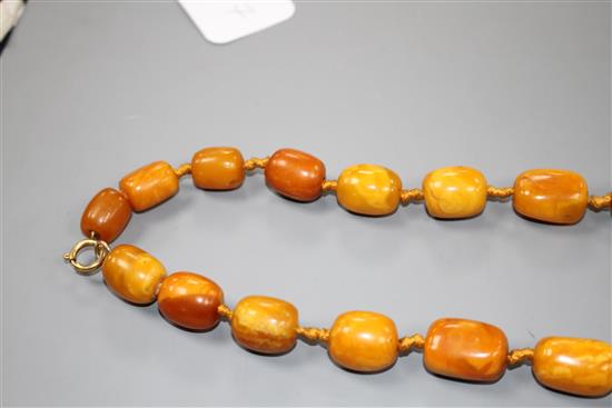 A single strand barrel shaped amber bead necklace, 86cm.